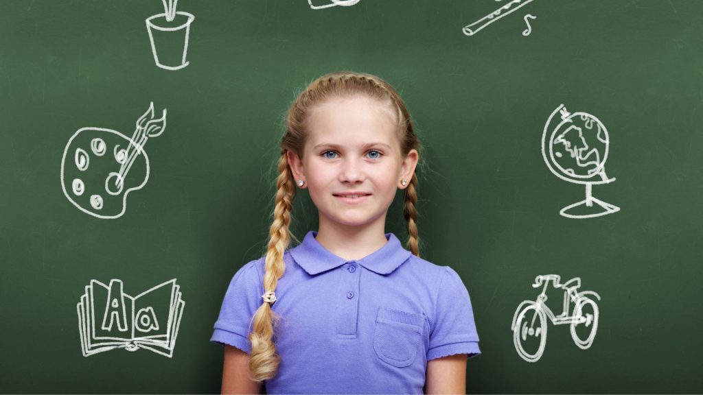 Photographie scolaire d'un portrait d'une élève d'école élémentaire, tableau avec dessins à la craie