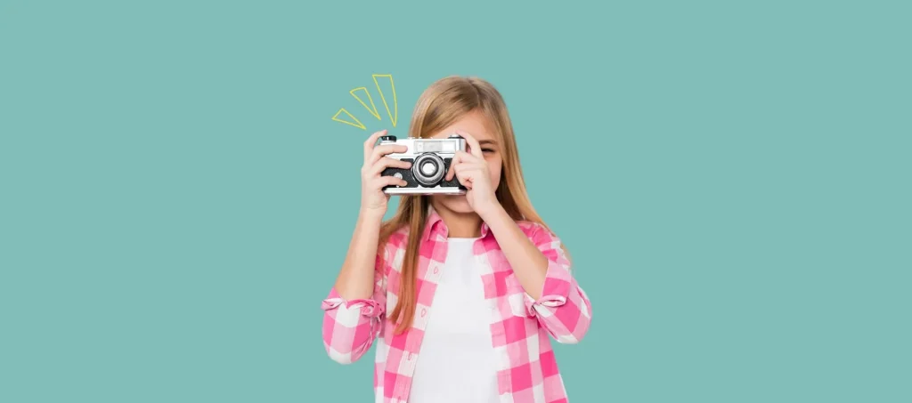 Une petit fille tenant un appareil photo - photo scolaire