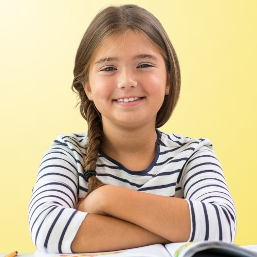 Photo scolaire d'une élève à son bureau